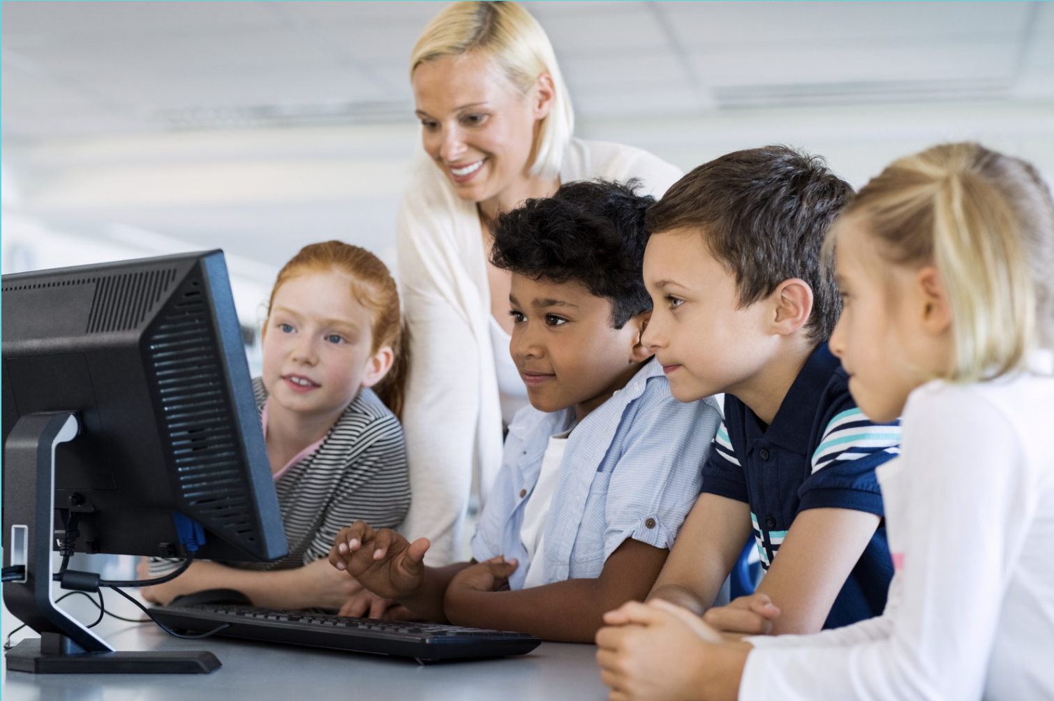 Young kids working on a computer with their teacher